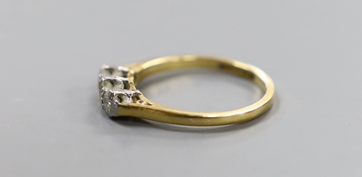 An 18ct, plat and three stone diamond set ring, size J, gross weight 2 grams.